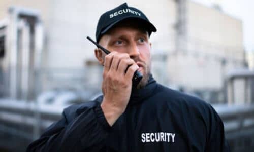 Un vigilante che comunica con il walkie talkie